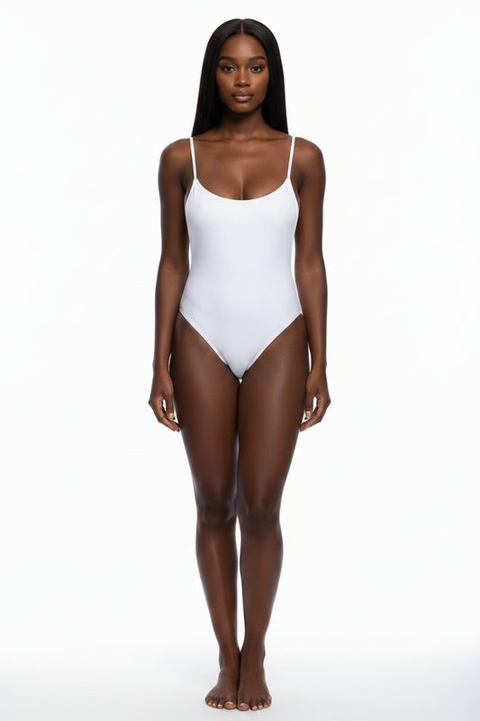 A woman modeling a white one-piece bodysuit with thin spaghetti straps and a scoop neckline, standing against a seamless white studio background.