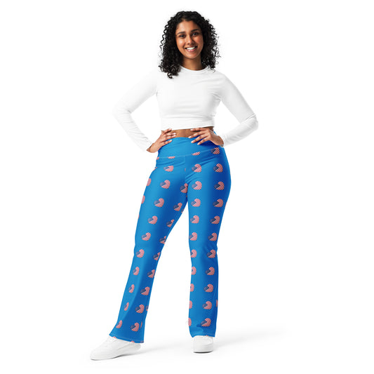 A person standing, wearing blue flare leggings with a print on the lower part of the legs, paired with a white top.
