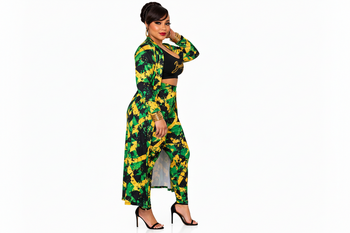 A woman modeling a matching two-piece outfit featuring a long-sleeve collared jacket and high-waisted trousers in a green, yellow, and black abstract pattern, paired with a black crop top and black high heels, set against a plain white background.