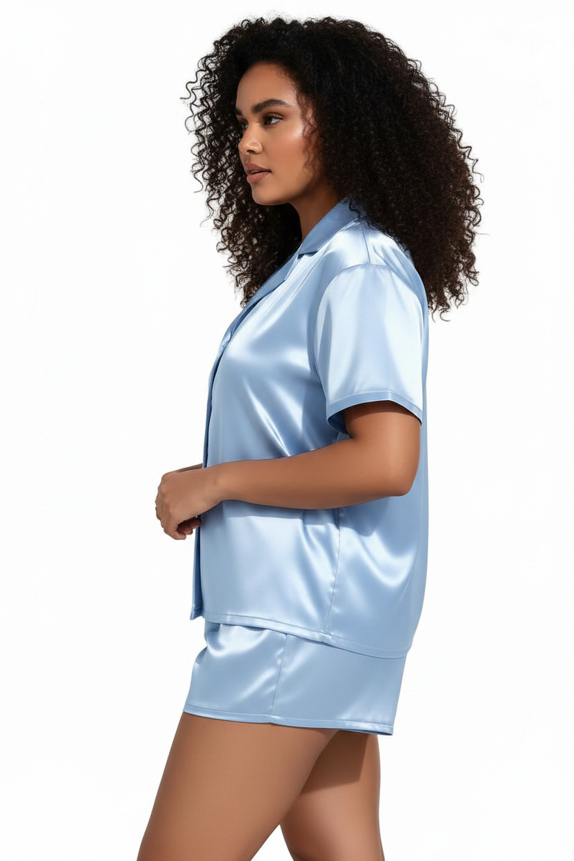 Woman wearing a light blue satin pajama set on a white background
