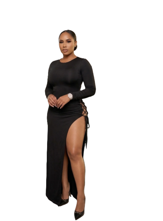 A woman modeling a long-sleeve black maxi dress with a high thigh slit and lace-up side detail, photographed against a plain white background.