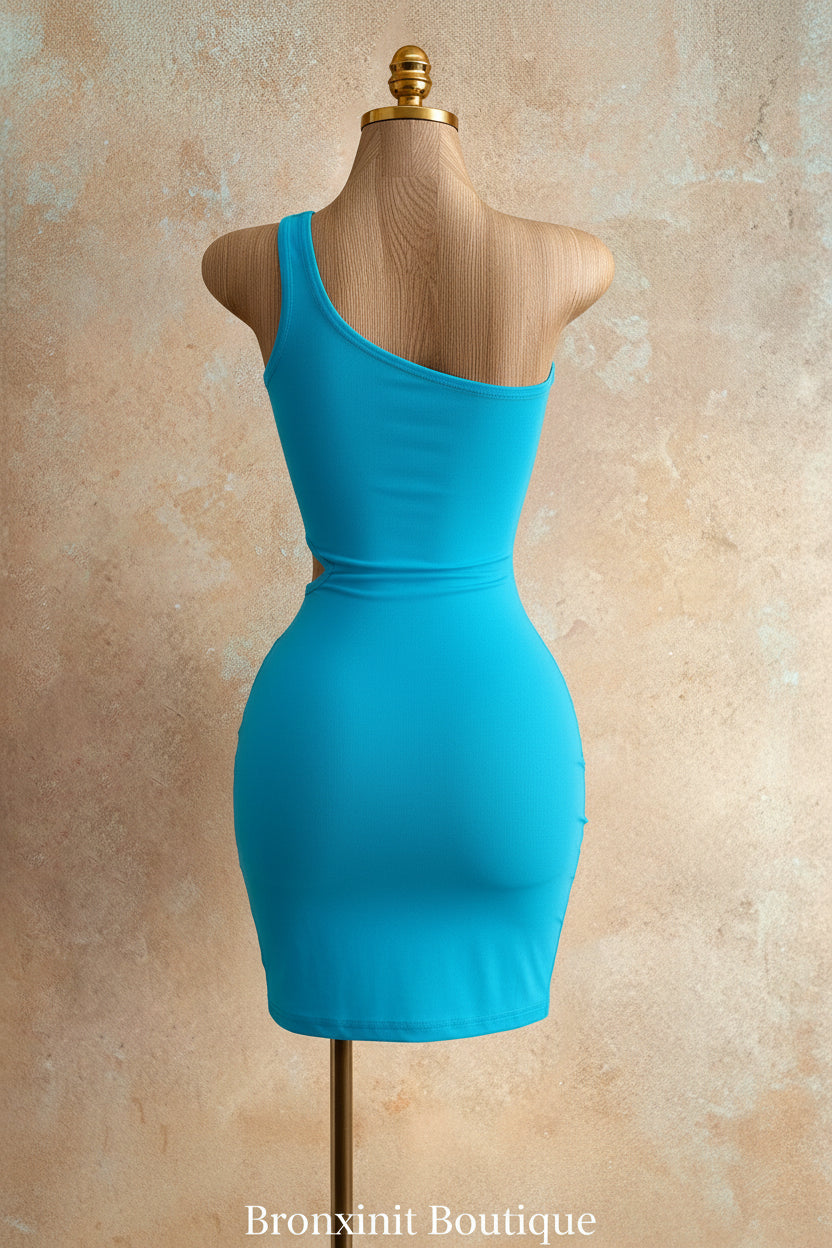 A bright turquoise blue one-shoulder bodysuit displayed on a wooden dress form mannequin against a textured beige studio backdrop.