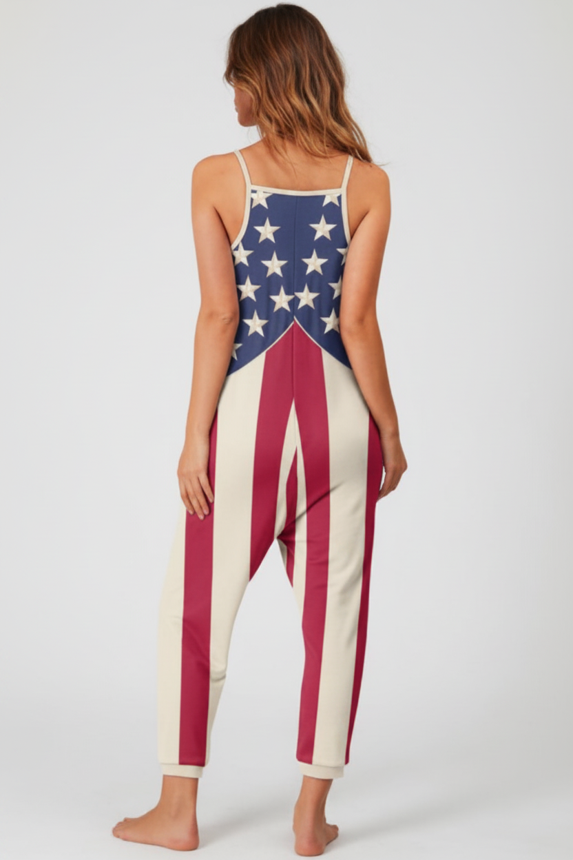 A woman modeling a sleeveless one-piece jumpsuit from the back, featuring an American flag-inspired design with white stars on a blue upper back and red-and-white vertical stripes on the lower body, against a light gray studio background.
