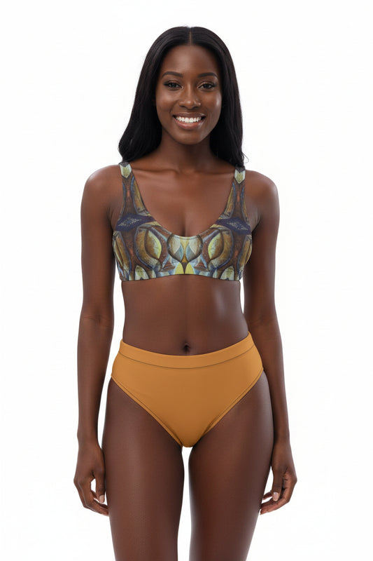 A woman modeling a two-piece bikini set against a plain white background. The bikini top features a detailed abstract pattern in shades of olive green, gold, and dark gray, while the high-waisted bottoms are a solid mustard yellow.